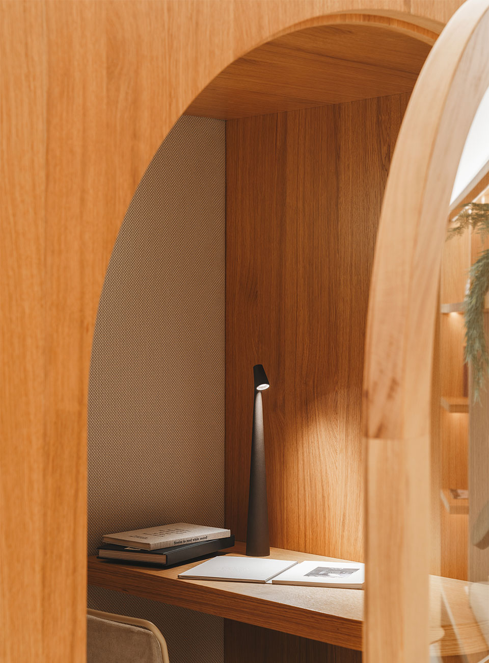 Wooden desk with a lamp and notebook inside a wooden archway